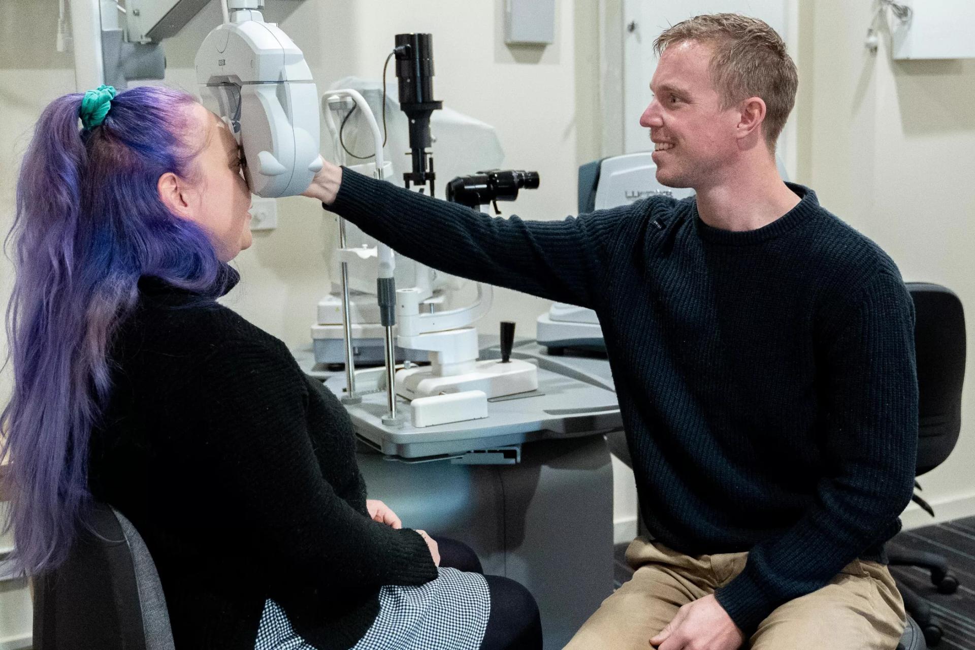 At Dresden Vision, a dedicated male optometrist performs a detailed eye test for a female patient, providing personalized vision care.