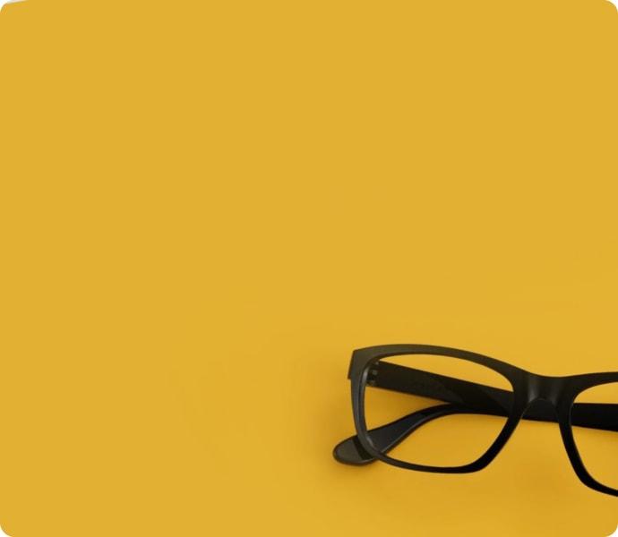 Dresden Vision's classic black frames set against a bold yellow backdrop, reflecting the stylish yet practical eyewear favored in New Zealand.