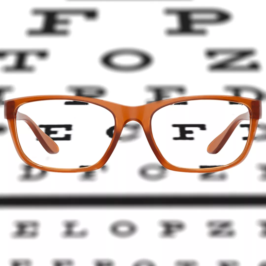 A brown Dresden eyeglasses placed on a Snellen chart, and on the lenses of the Dresden eyeglasses the letters E and F is emphasized.