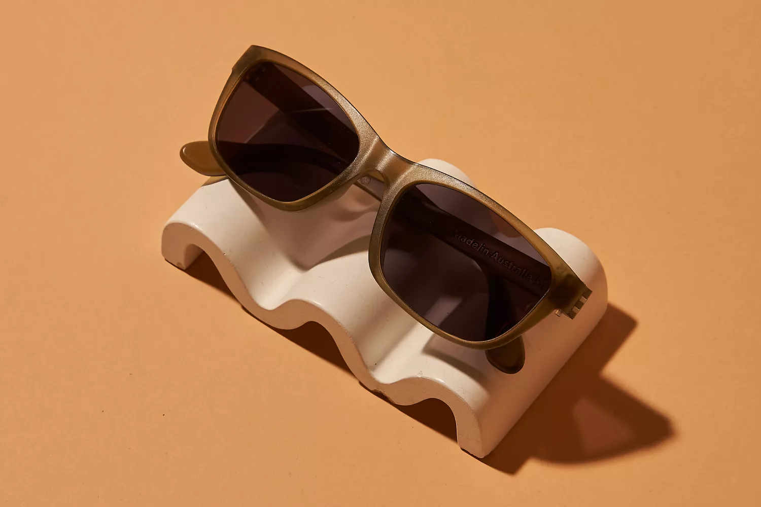 A brown Dresden sunglasses placed on top of a wavy object.